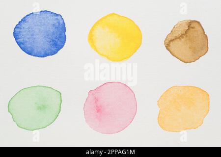 Blue yellow brown green pink orange paints white paper Stock Photo