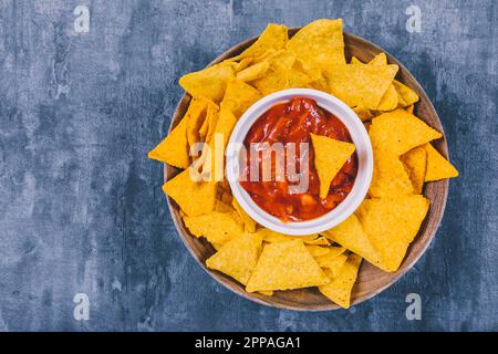 Top view mexican nachos chips with spicy salsa sauce container Stock Photo