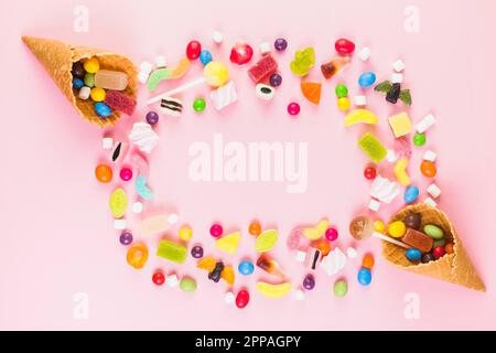 Colorful sweet candies with two ice cream waffle cone pink surface Stock Photo