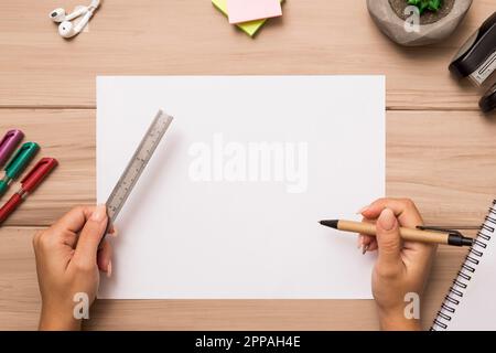 From hands holding ruler pen blank paper sheet Stock Photo