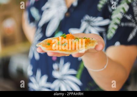 Ancient Thai Crispy Pancake on hand Is a sweet dessert, flour with various flavorings Stock Photo