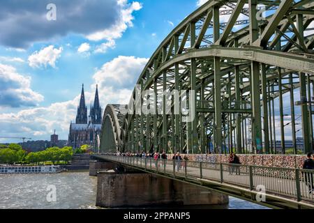 COLOGNE, GERMANY - MAY 12: Tourists on Hohenzollern bridge in Cologne, Germany on May 12, 2019. View to Cologne Cathedral Stock Photo