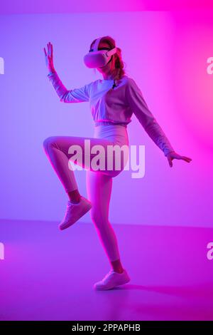 Fit woman doing workout using virtual reality headset Stock Photo