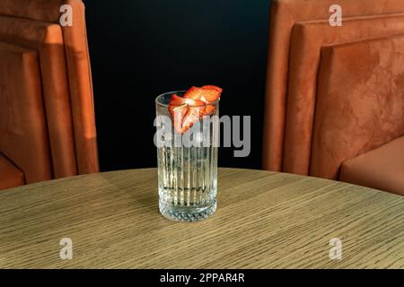 Summer cocktail garnished with strawberries. cold beverage on bar terrace. Stock Photo