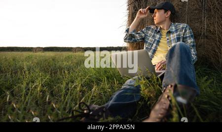 Farmer with laptop on the field. Smart farming and agriculture digitalization. High quality photo Stock Photo