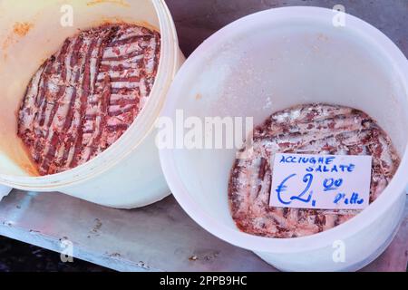 Buckets containing salted anchovies (Engraulis encrasicolus) in Catania fish market, sicily, Italy Stock Photo