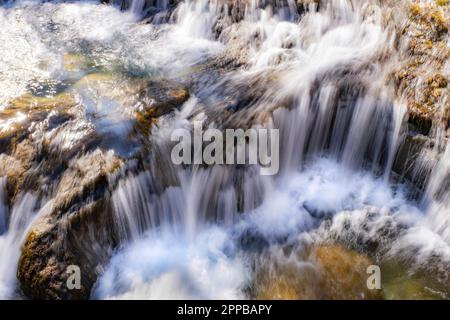long exposure in a small waterfall in a mountain river of fresh and pure waters, mountain snowmelt torrent Stock Photo
