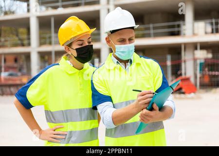 Civil engineers in masks checking work process Stock Photo