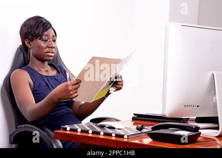 portrait of a concentrated young businesswoman checking contract in document at office. Stock Photo