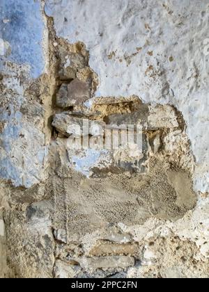 texture of a deteriorated old wall, with a partially repaired spalling, vertical Stock Photo