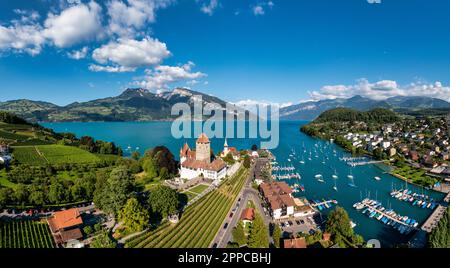 Aerial panoramic view of Spiez Church and Castle on the shore of Lake Thun in the Swiss canton of Bern at sunset, Spiez, Switzerland. Spiez Castle on Stock Photo
