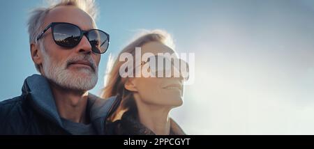 Portrait of couple of senior adult man and woman in sunglasses having fun together in friendship over blue sky. Sunglasses sale banner. summer Stock Photo