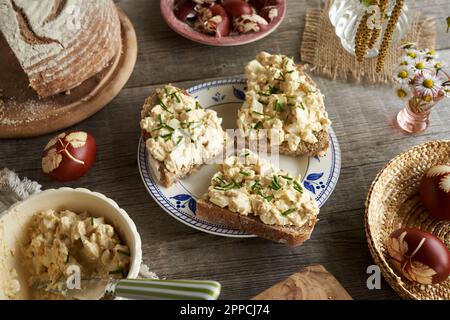 Slices of sourdough bread with spread made of hard-boiled Easter eggs and cottage cheese in spring Stock Photo