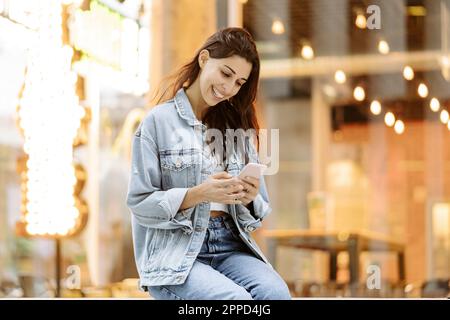Happy young woman using smart phone Stock Photo