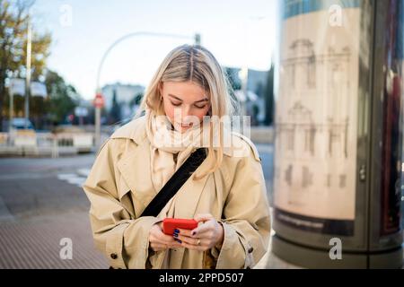 Young woman with blond hair using smart phone Stock Photo