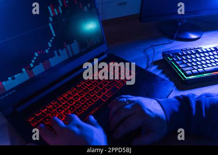 Hands of hacker using illuminated keyboard at home Stock Photo
