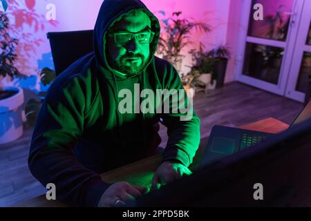 Hacker using laptop at home Stock Photo