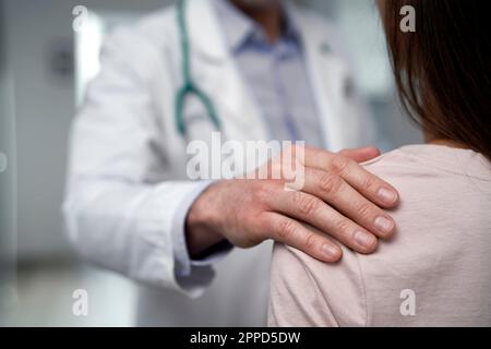 Doctor consoling patient at clinic Stock Photo