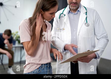Mature doctor discussing over document with patient Stock Photo