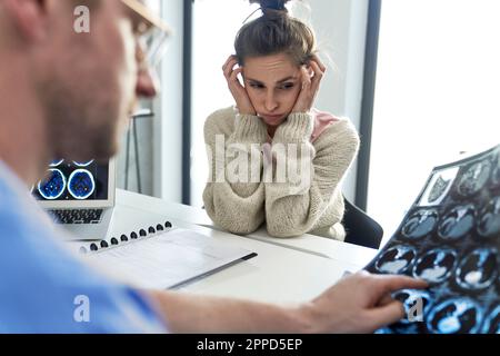 Doctor discussing over medical x-ray image with patient Stock Photo