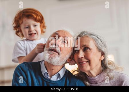 Playful boy with grandparents spending leisure time at home Stock Photo