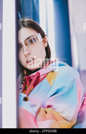 Young woman wearing smart glasses leaning on wall Stock Photo