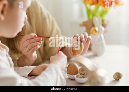 Mother and son decorating Easter eggs at home Stock Photo
