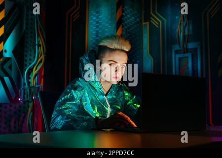 Gamer wearing headset playing video games on laptop at desk Stock Photo