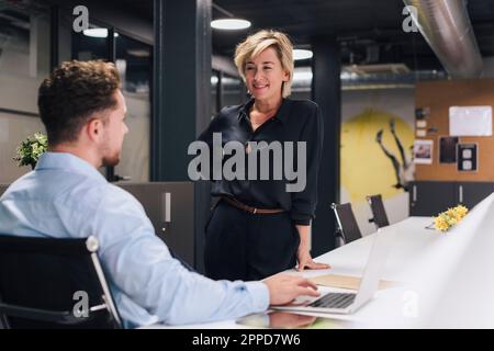 Young businessman having discussion with businesswoman in office Stock Photo