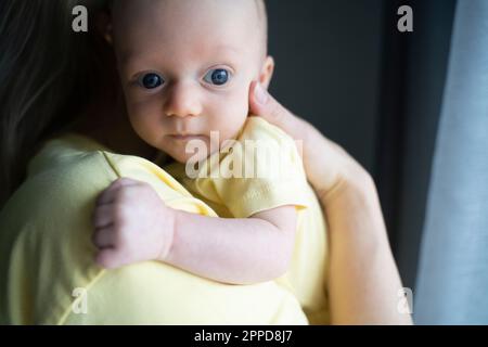 Mother carrying cute baby boy in arms Stock Photo