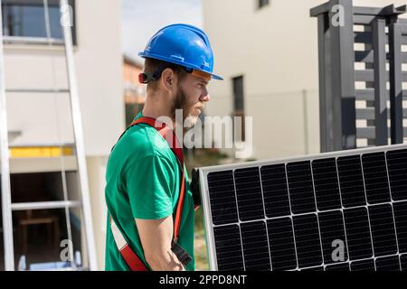 Technician holding solar panel on sunny day Stock Photo