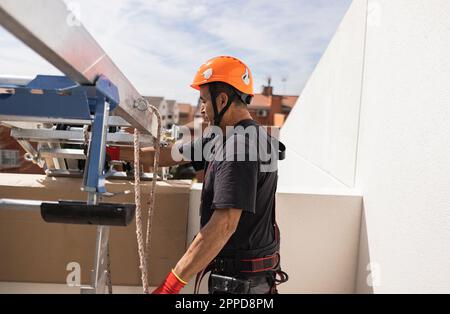 Engineer wearing hardhat standing by ladder on sunny day Stock Photo