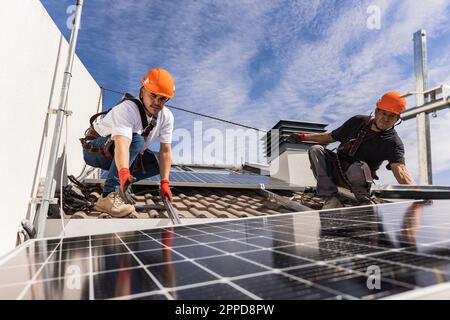 Engineers working with solar panels on rooftop Stock Photo