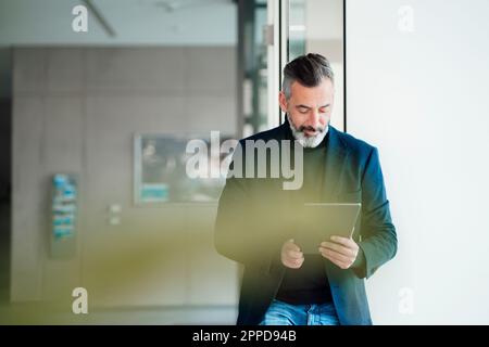 Mature businessman using tablet PC at office Stock Photo