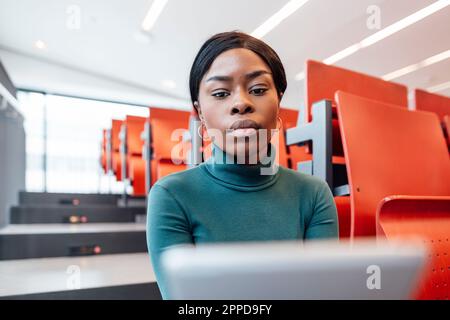 Young woman using tablet PC in auditorium Stock Photo