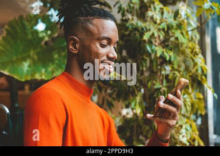 Smiling young man using smart phone Stock Photo