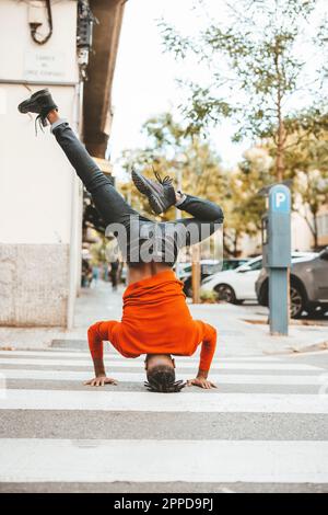 Carefree man doing headstand on zebra crossing at road Stock Photo
