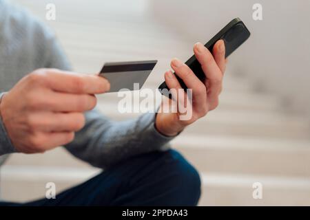Hands of businessman holding credit card and smart phone Stock Photo