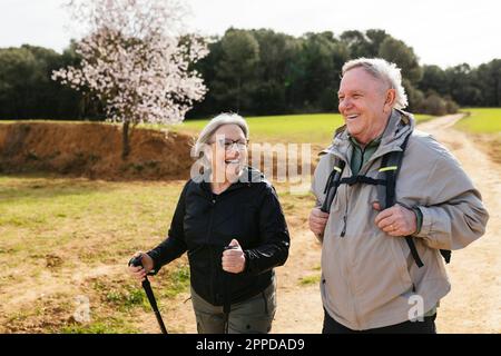Senior couple hiking together on hiking path Stock Photo