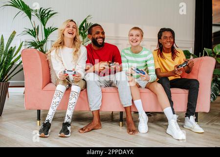Happy men and women playing video game at home Stock Photo