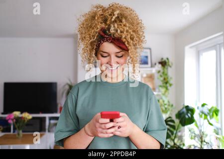 Happy young woman using smart phone Stock Photo