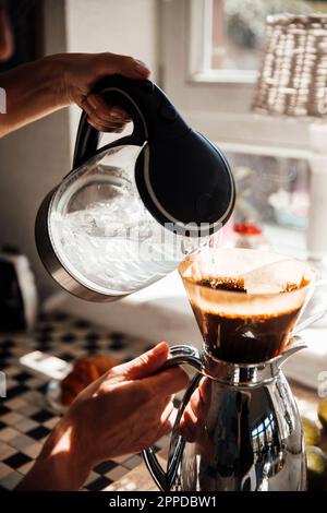 Woman preparing coffee in kitchen at home Stock Photo