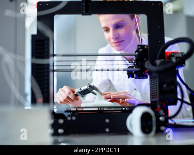 Engineer using vernier calliper operating on 3D printing machine Stock Photo