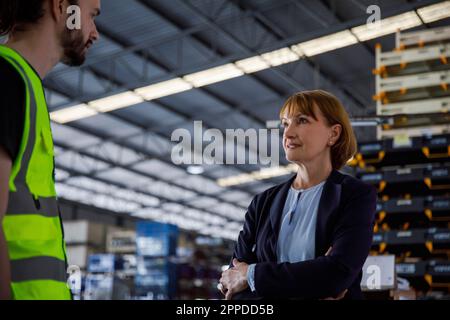 Mature manager talking with colleague at warehouse Stock Photo