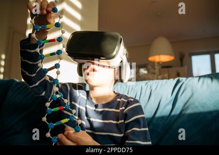 Boy wearing VR glasses examining DNA Stock Photo