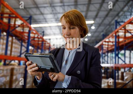 Mature manager using tablet PC at warehouse Stock Photo
