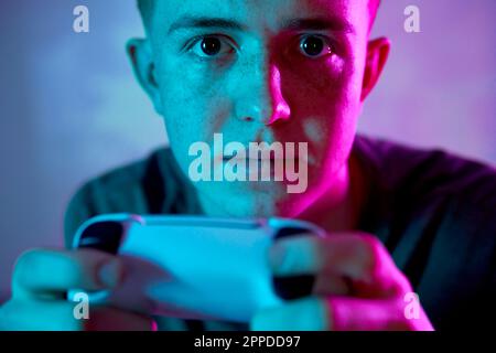 Young man with controller playing video game Stock Photo