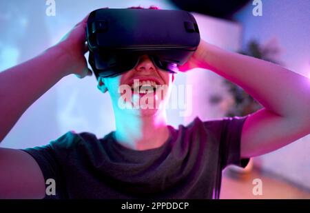 Happy man wearing virtual reality simulator at home Stock Photo