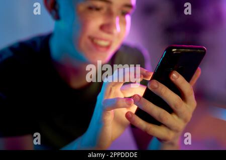 Smiling young man using smart phone Stock Photo