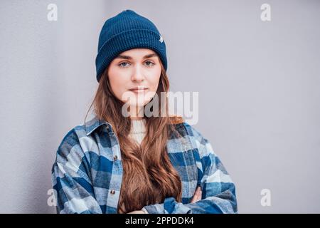 Young woman wearing knit hat in front of wall Stock Photo